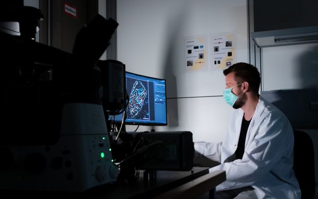 MDC-Doktorand Jan Möller im Labor vor dem hochauflösenden Bild des untersuchten Rezeptors. © Felix Petermann, MDC
